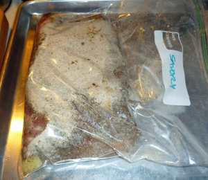 Pork belly coated with salt, sugar, and spice mix in resealable plastic bag