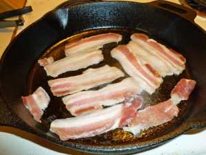 "Green" bacon frying in cast iron